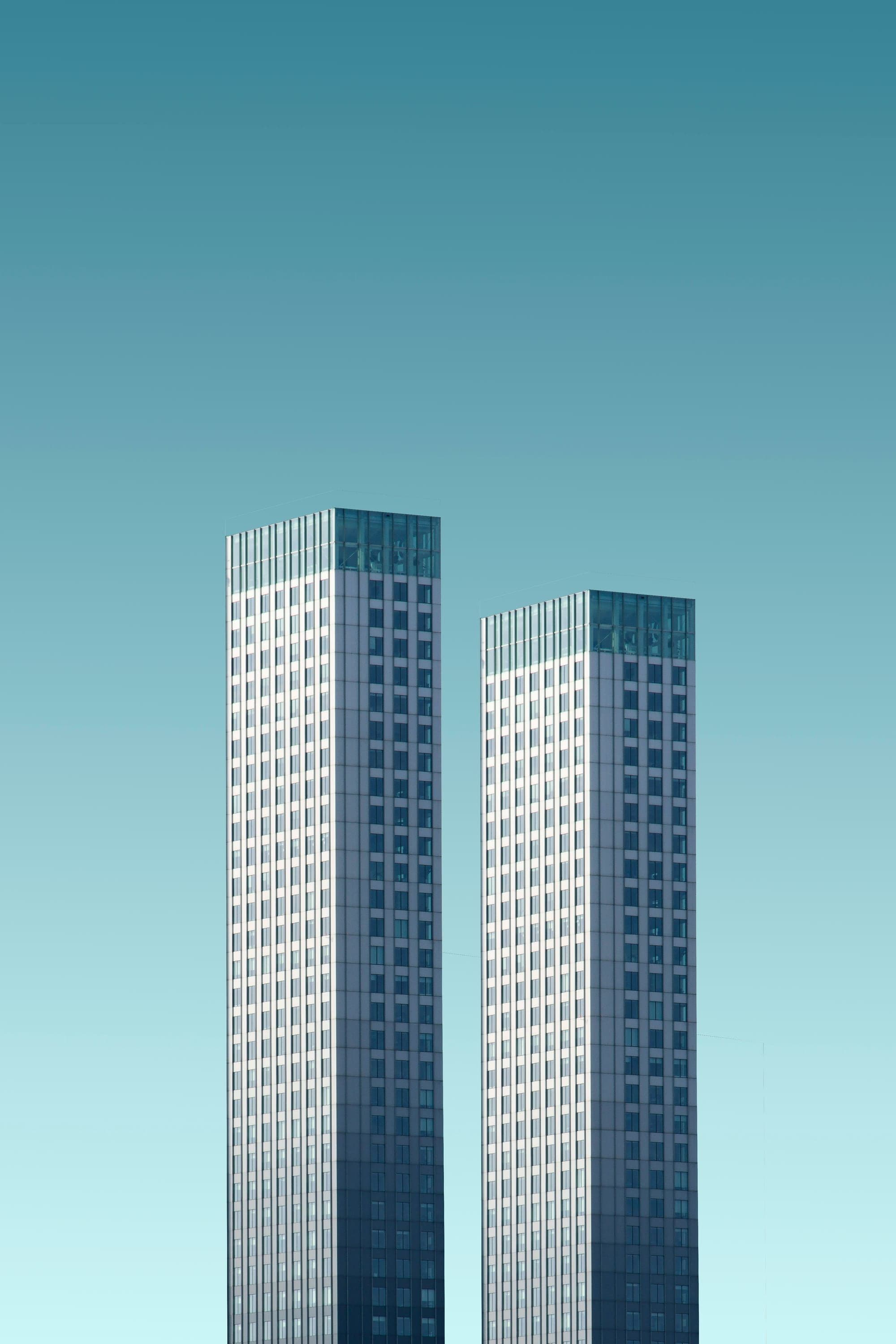 Twin commercial towers against teal sky